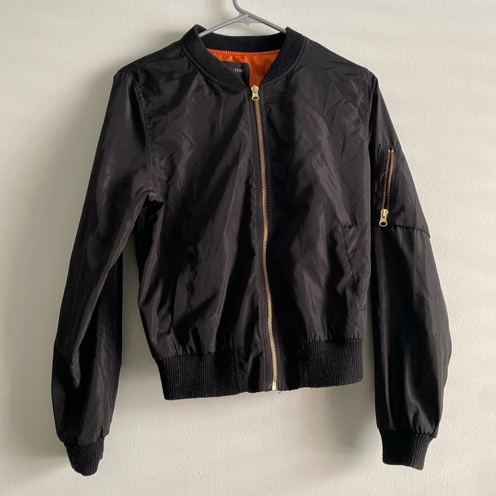 black bomber jacket, orange lining, gold zipper details